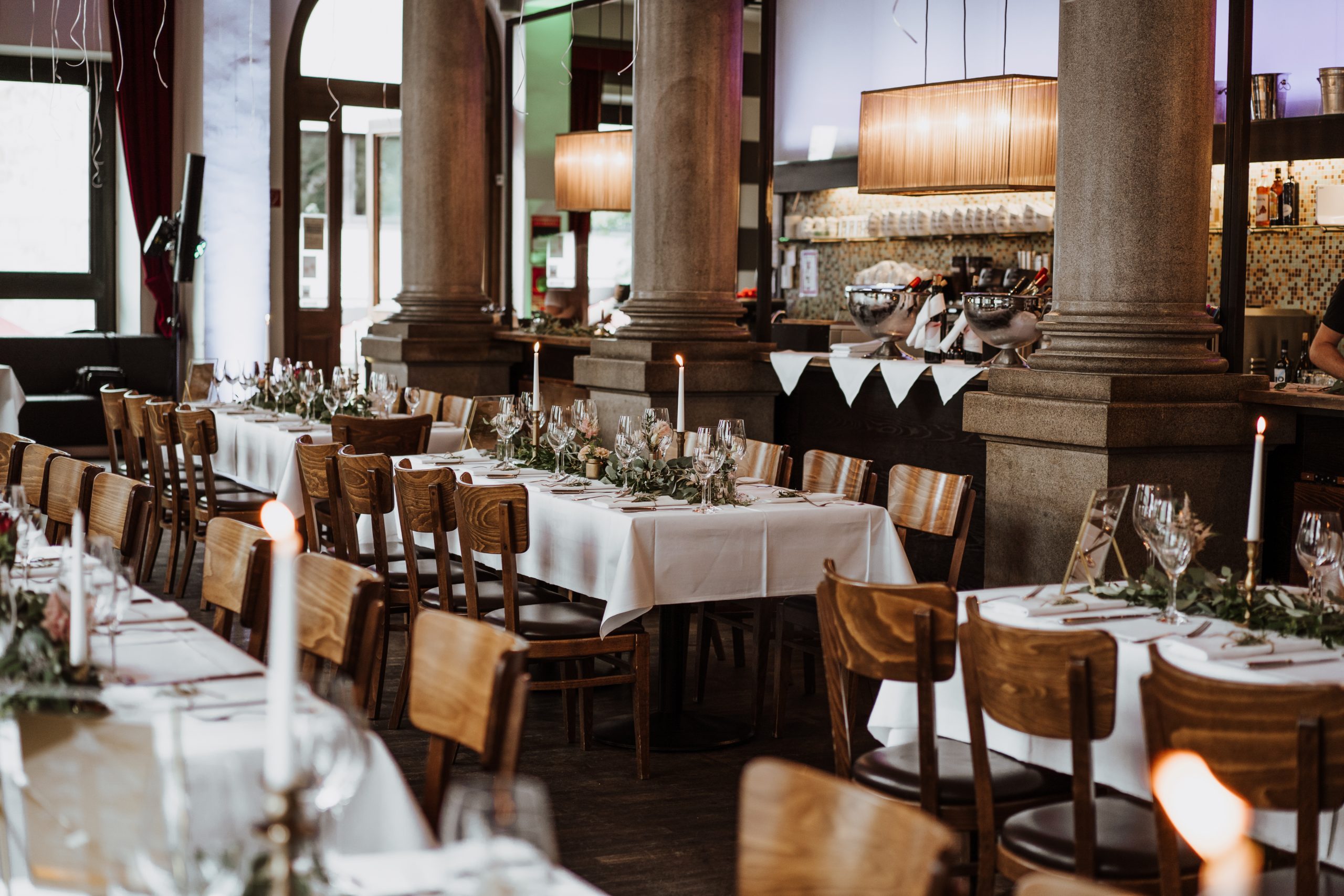 Lange Tafel mit Kerzen unter den Sandsteinsäulen